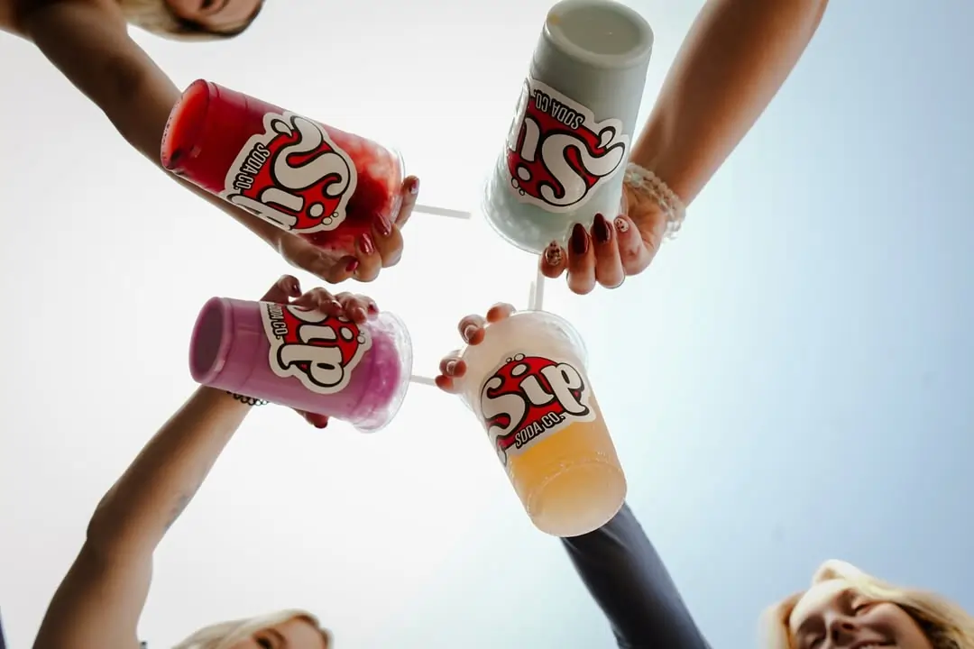 customer ordering a customized dirty soda drink with syrups and cream at a soda café counter