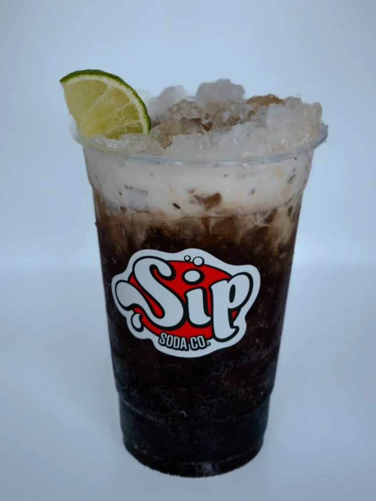 Dirty Dr. Pepper in a Sip Soda cup with nugget ice, cream mix-in, and a lime wedge